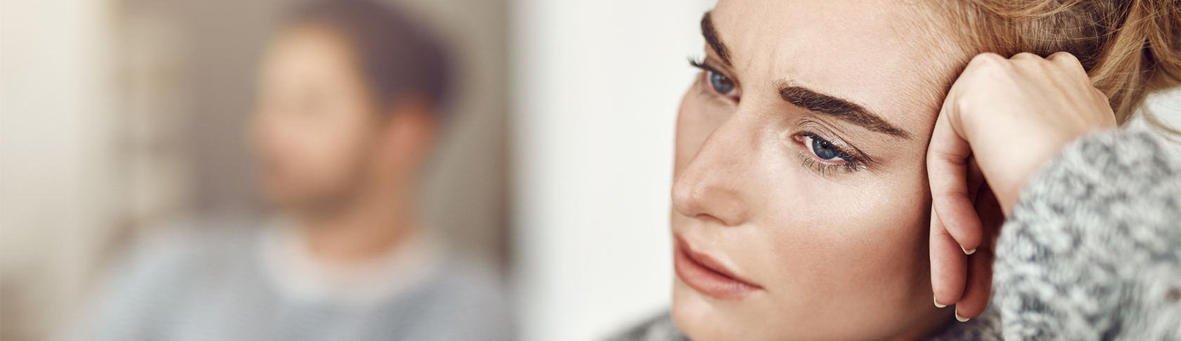 Une femme regarde au loin de manière pensive. 