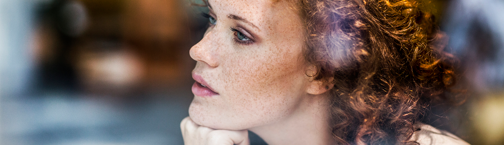 A woman is looking pensively into the distance. 